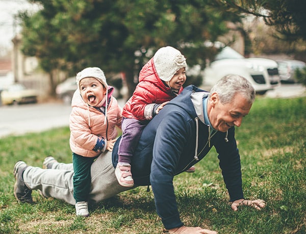 older man playing with granddaughters
